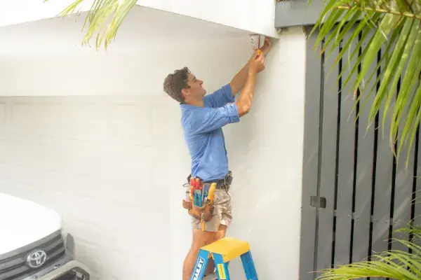 Alltronic security technician installing security camera system on exterior of building
