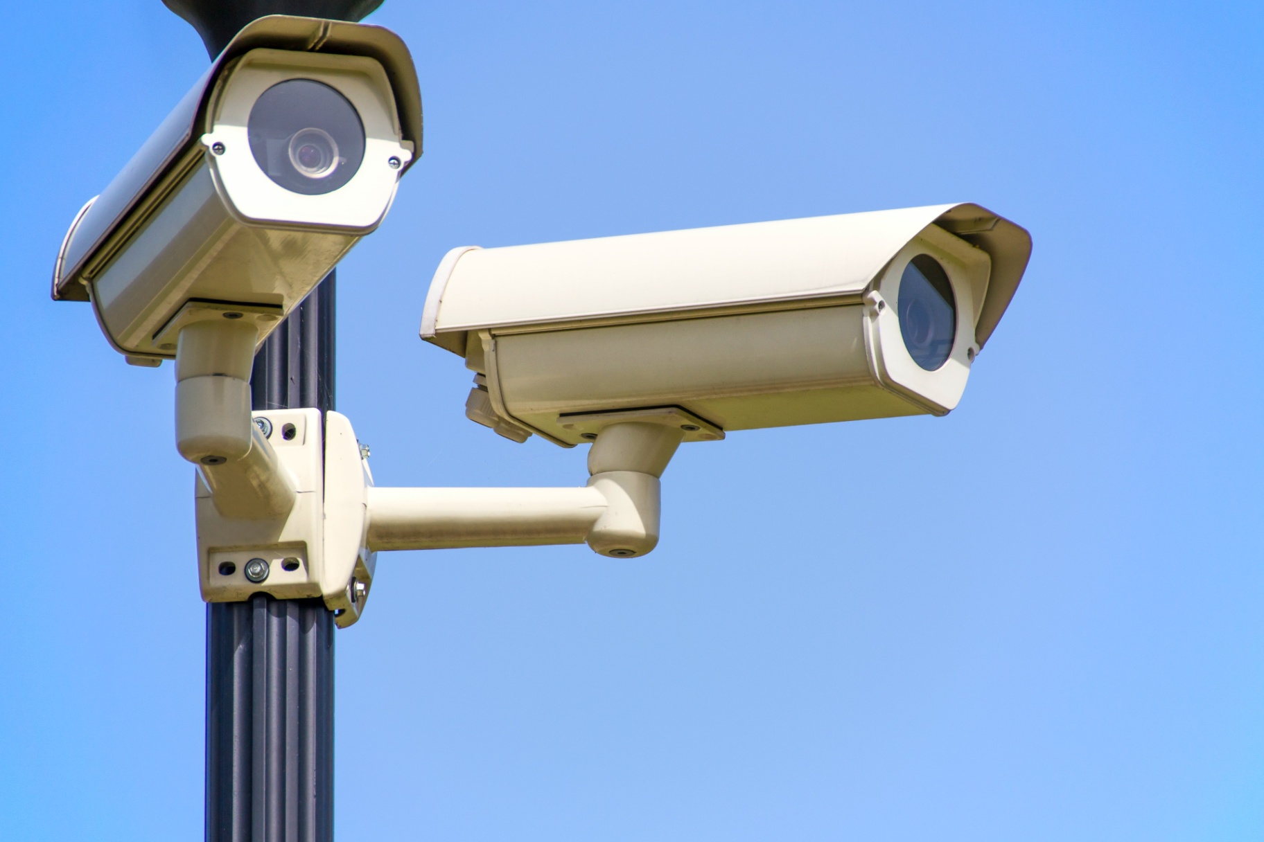 Surveillance cameras facing different directions on a pole