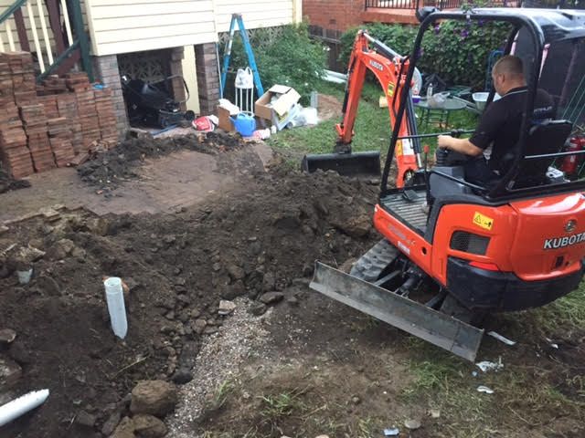 Everyday Plumber using excavator to cover new drains Plumber using excavator to dig drainage