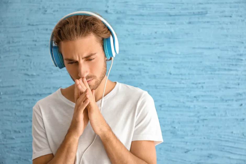 Man listening to modern funeral music through headphones. songs remind him of his loved one and evoke sadness, joy, mixed emotions remembering and celebraing the life they lived. 