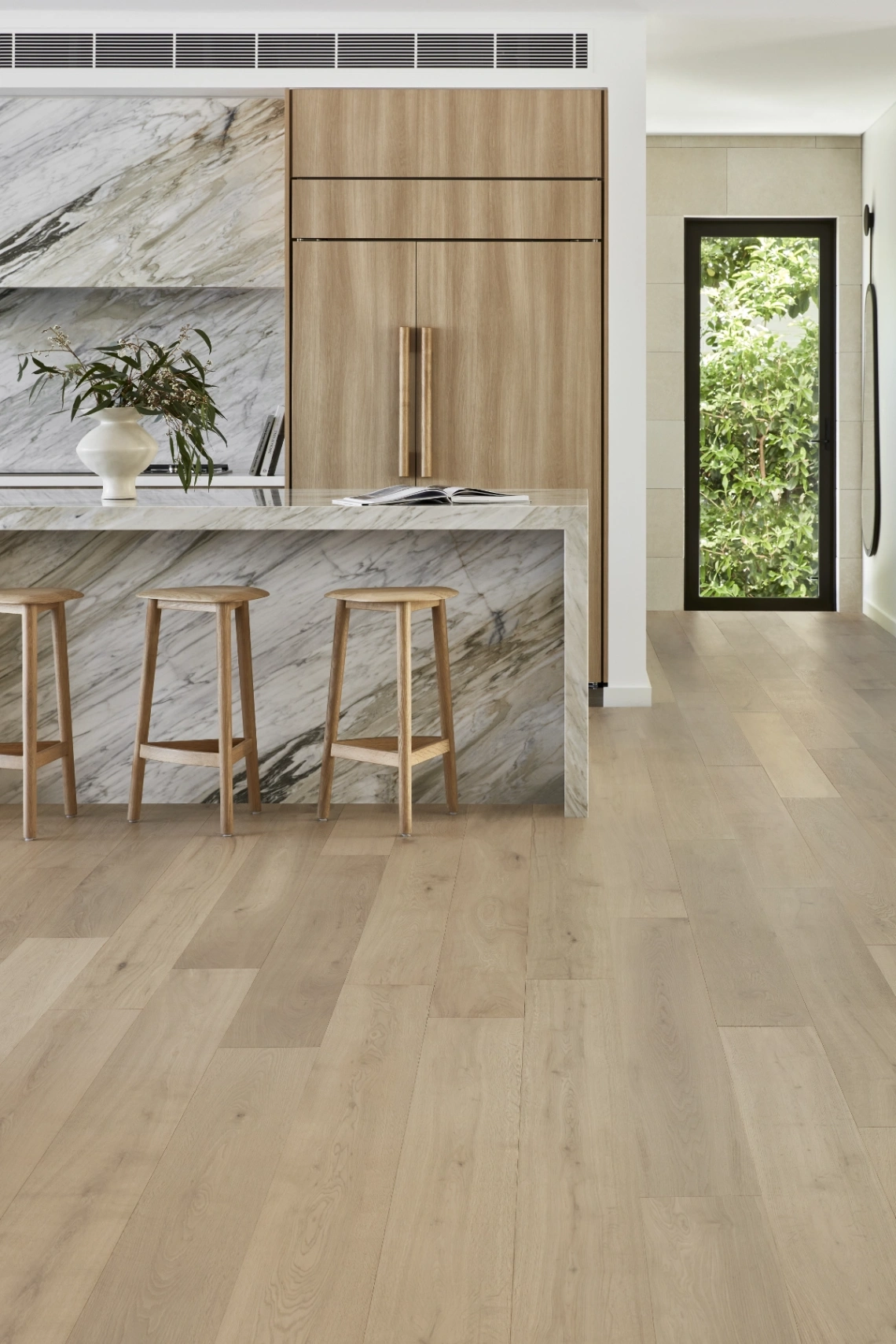 Natural Oak Flooring in warm honey tones and beautiful grain variations in each floorboard spanning across a modern kitchen