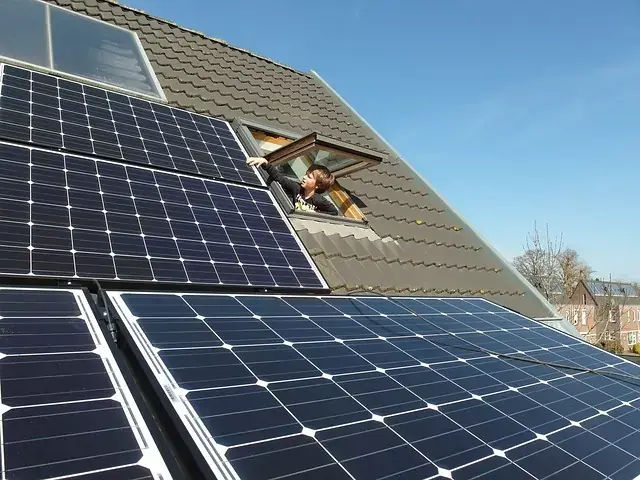 solar panels on roof with boy looking out of the window