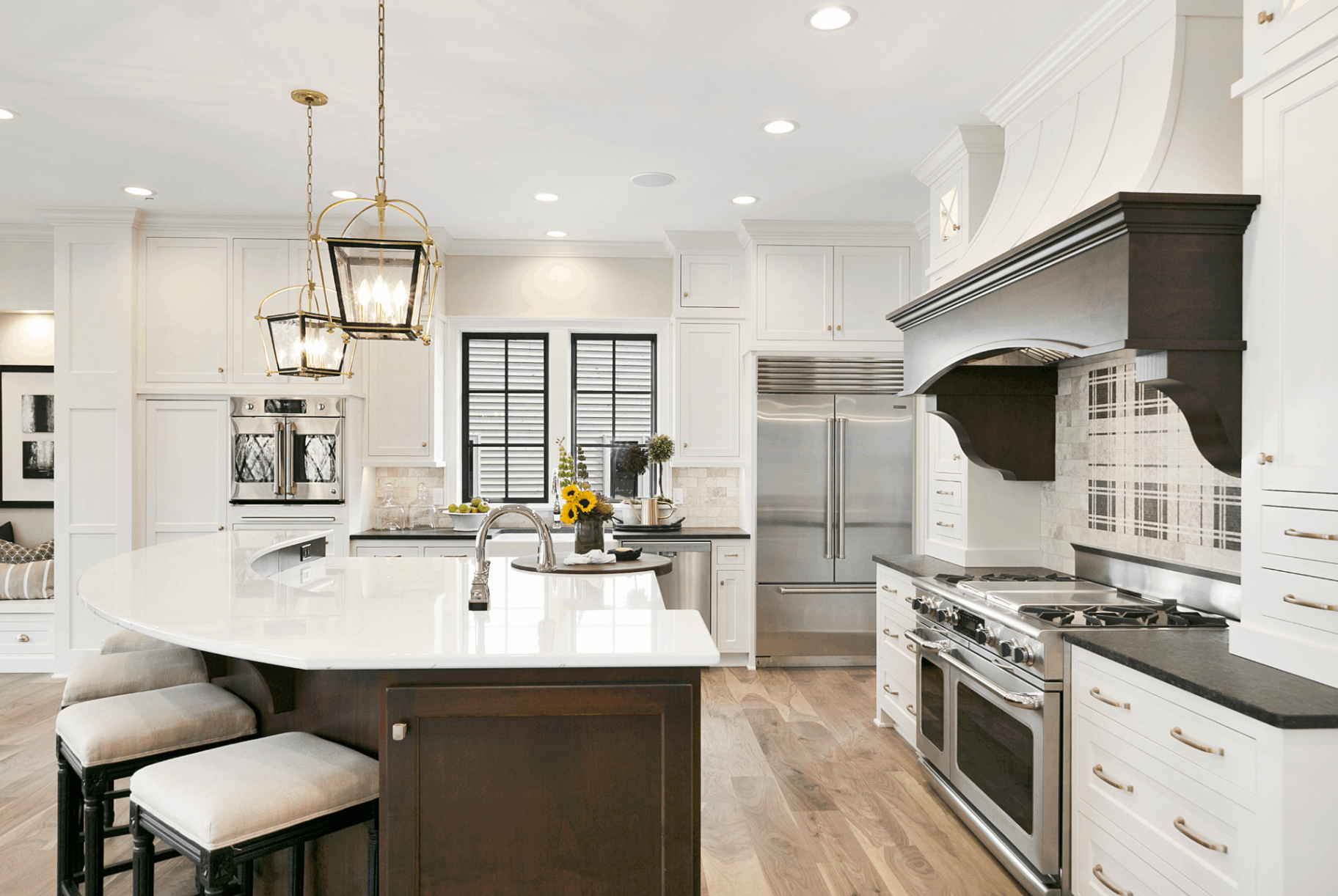 Kitchen featuring island that curves around in an arch shape. Incorporating curves and arch shapes are very on trend this spring!