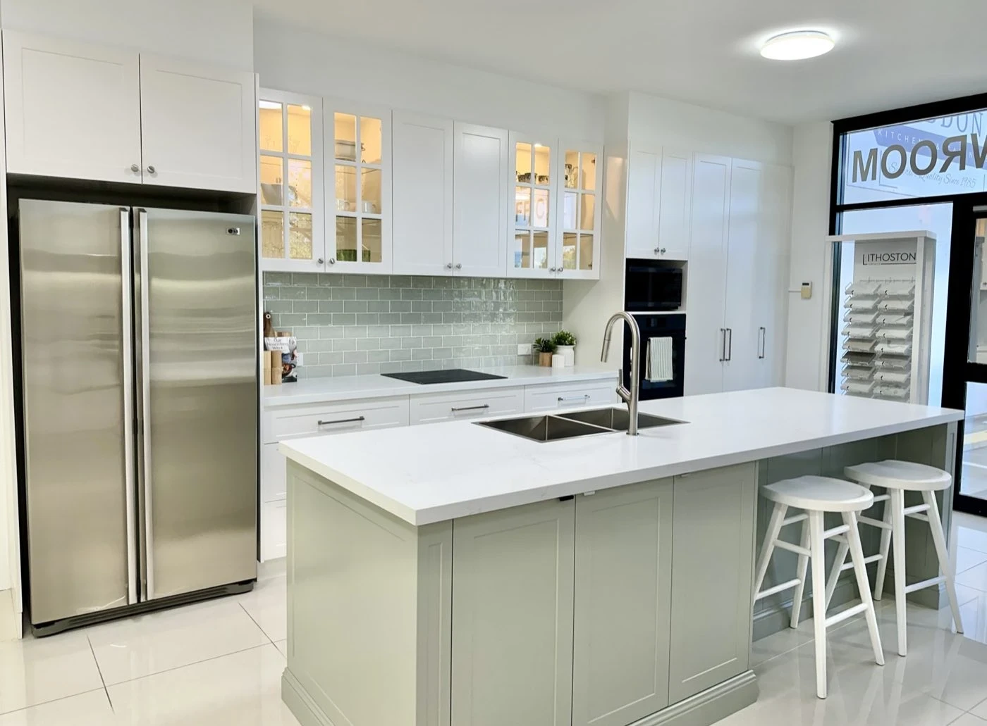 Shaker display kitchen with sage green island and glass overhead cabinets