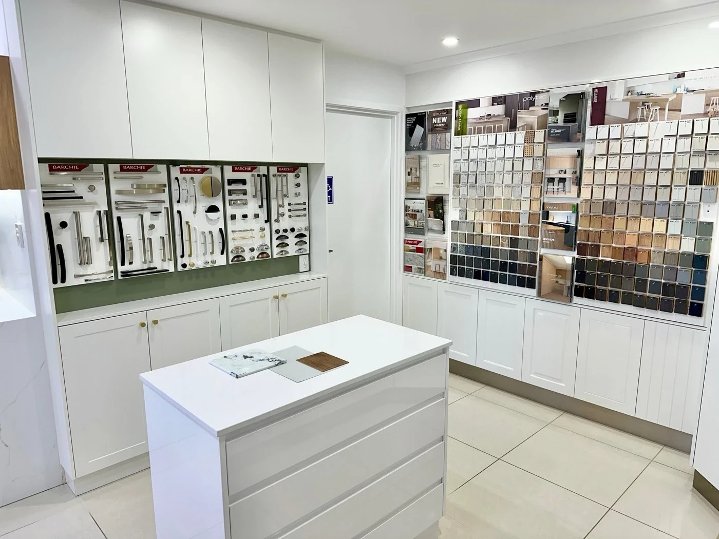 Cabinet handle displays and door finish samples on the showroom wall