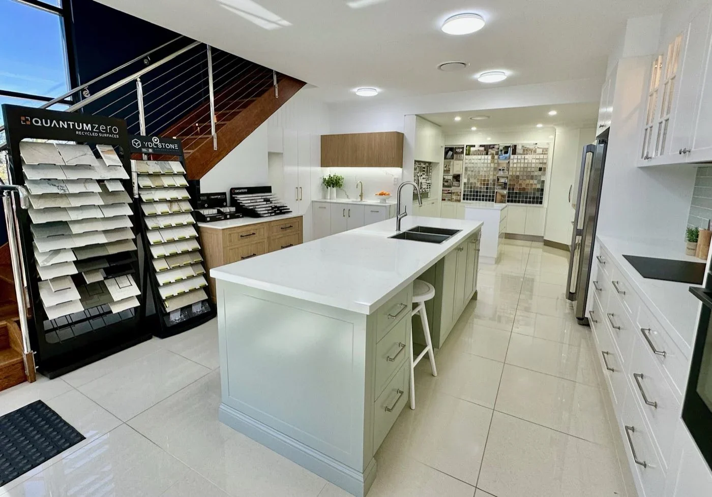 Benchtop sample stands beside a sage green display kitchen island