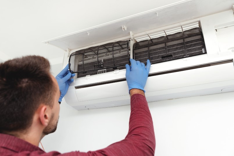 Split system air conditioner being serviced and cleaned by HVAC technician