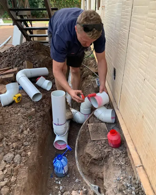 Plumber installing new pipes into drainage system