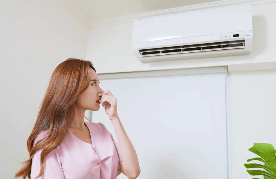 woman holding nose under AC