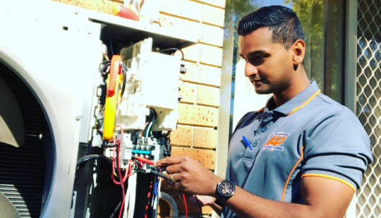 Air conditioning technician repairing aircon