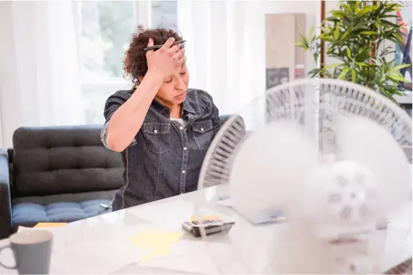Woman cooling herself in front of a fan