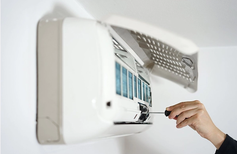 Technician servicing a Gree AC unit