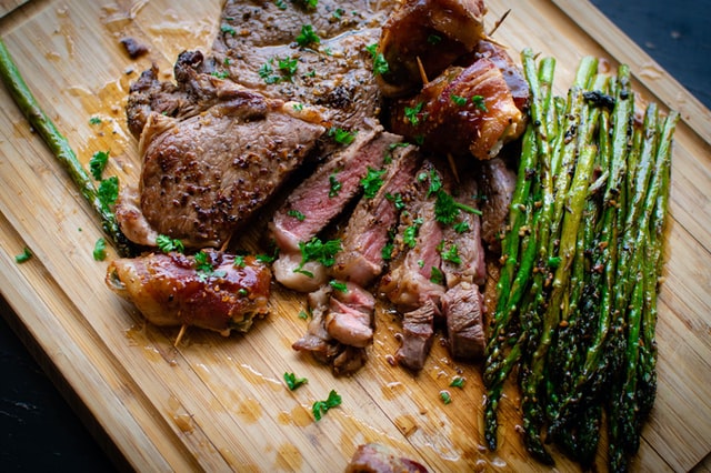Steak and asparagus on chopping board