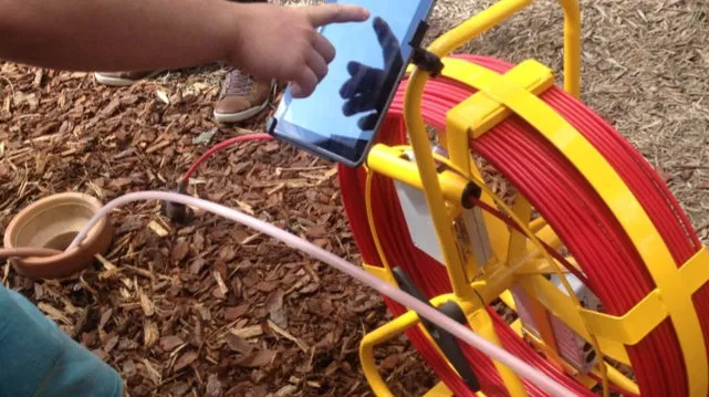 CCTV drain camera being inserted into drain pipe to look for any damaged pipes or blockages