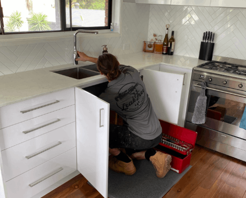 technician working on kitchen sink