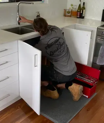 plumber repairing kitchen plumbing 
