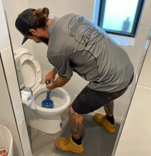 plumber unblocking a toilet