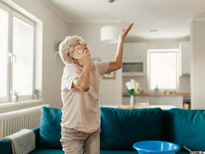 Woman standing under leaking roof