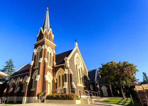 A picturesque view of Armidale, showcasing its historic cathedrals and classic architecture, nestled within a backdrop of rolling hills and verdant landscapes, reflecting the city's blend of cultural heritage and natural charm. 