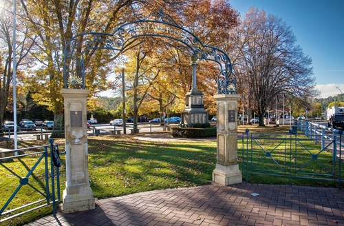 The picturesque streets of Bowral, showcasing its cultural charm with a mix of quaint cafes, boutique shops, and the Bradman Museum, set against the backdrop of the town's lush gardens and historic architecture.