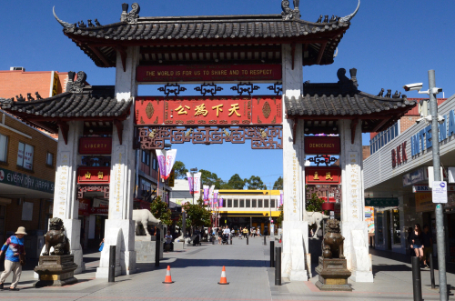 A lively scene in Cabramatta, where the streets burst with the colours and aromas of Vietnamese cuisine. Markets and shops display an abundance of exotic fruits, delicious street foods, and cultural merchandise, capturing the essence of the Vietnamese-Australian community's vibrant life.