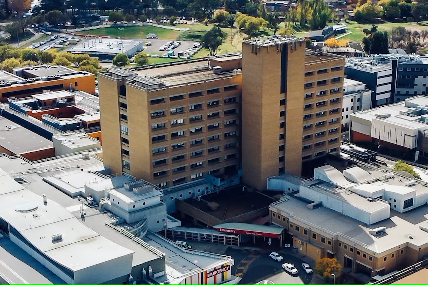An exterior shot of Canberra Hospital, depicting its state-of-the-art facilities, landscaped grounds, and dedicated medical staff, conveying a sense of professionalism and care in providing healthcare services to the community. 
