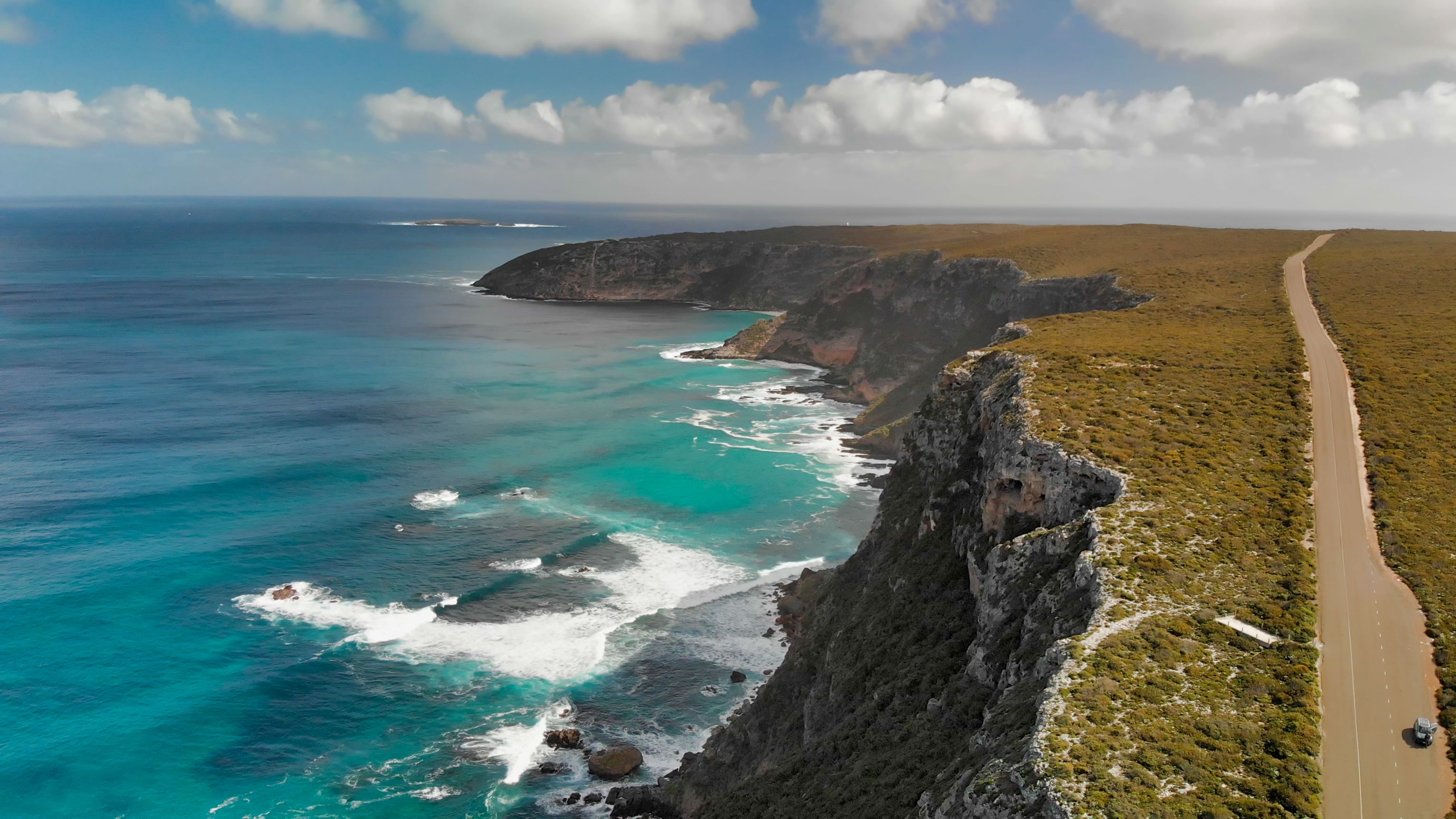 Admirals Arch, a natural rock archway carved by the sea, with crashing waves below. 