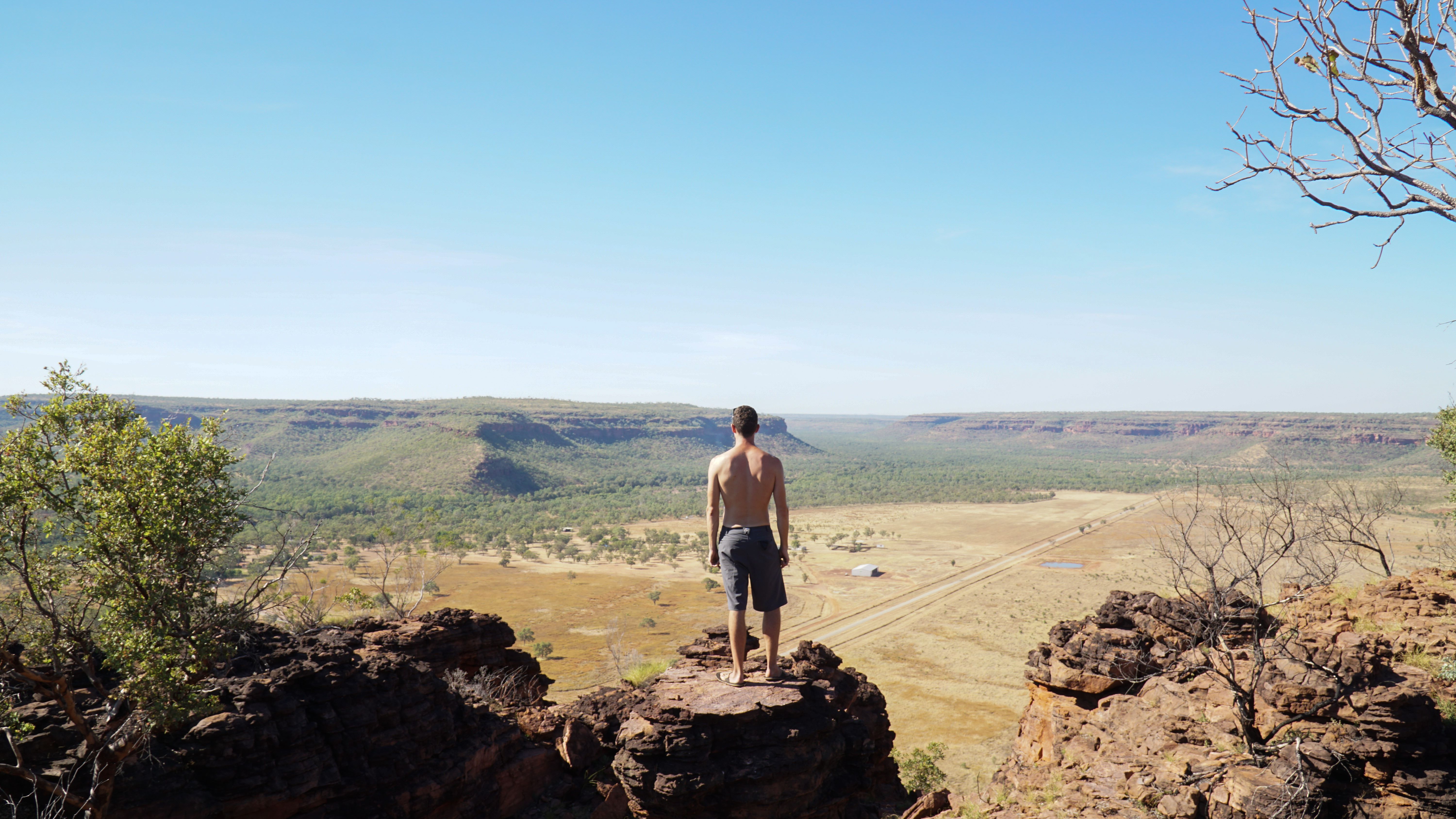 A panoramic view of the rugged terrain of Gregory National Park, with rocky cliffs, spinifex grass, and clear blue skies. 