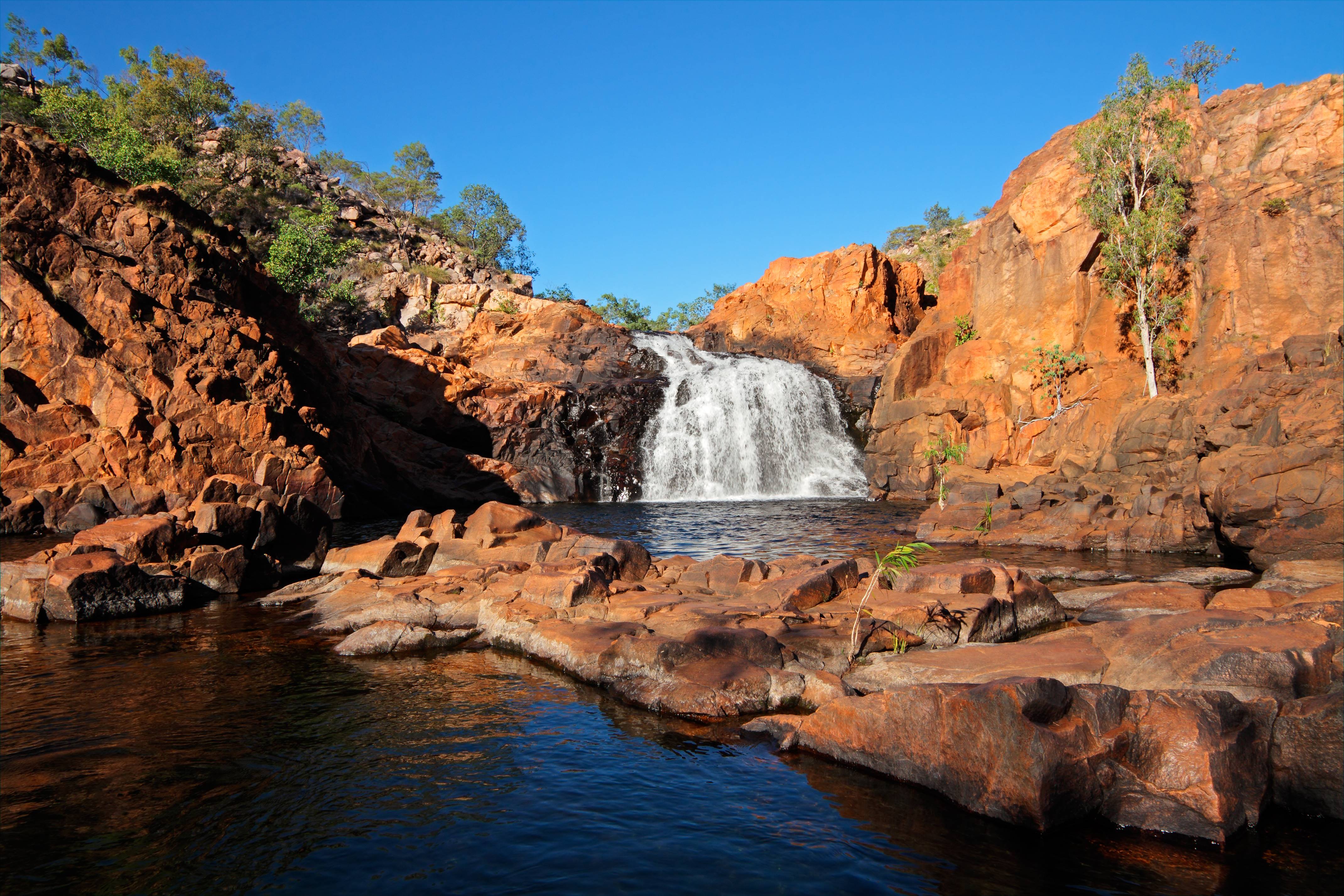 A breathtaking view of Kakadu National Park's rugged landscape, with lush greenery, winding rivers, and dramatic cliffs, showcasing the park's natural beauty and cultural significance. 