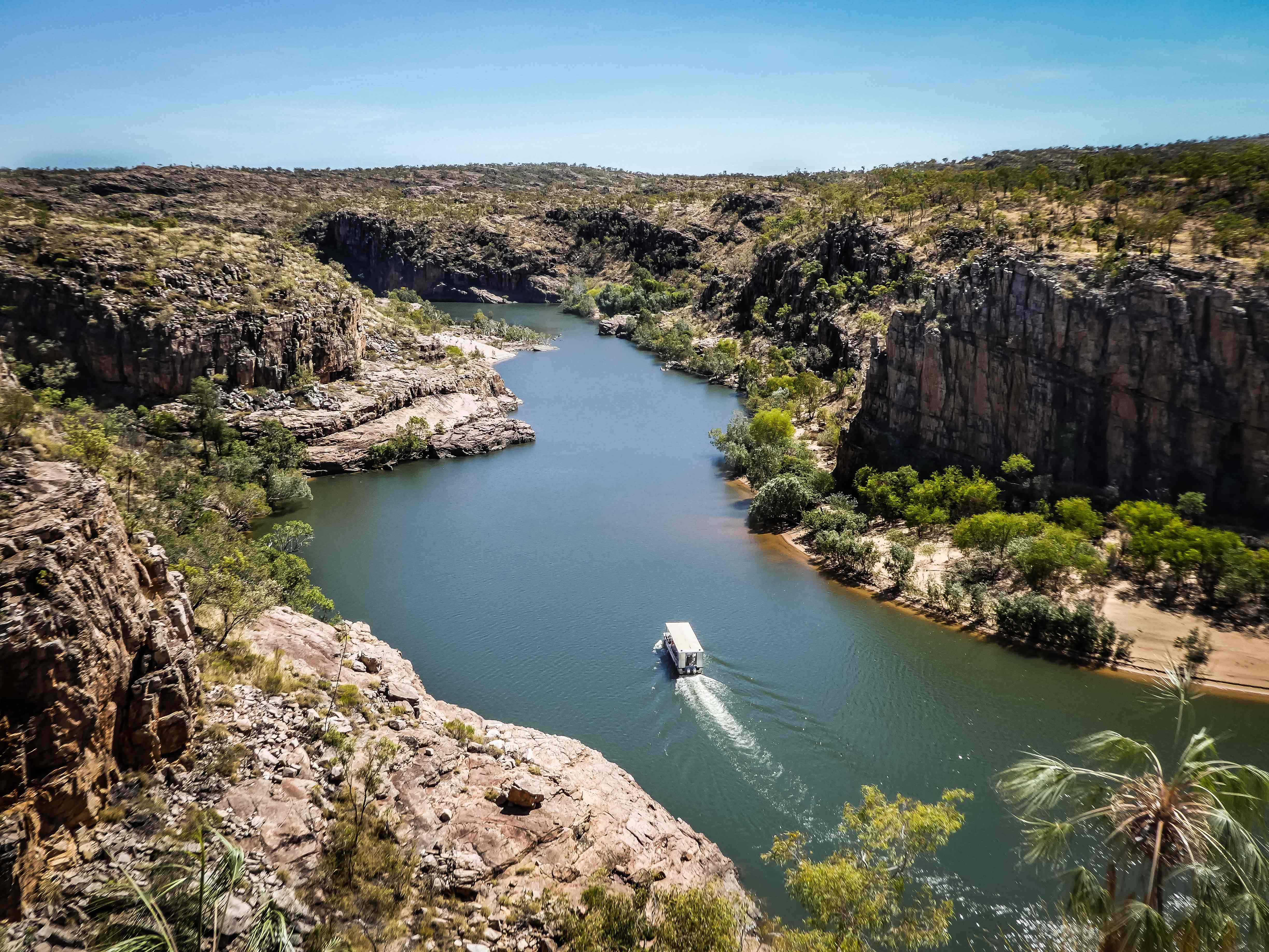A photo of the towering sandstone cliffs of Katherine Gorge, with the turquoise waters of the Katherine River flowing through. 