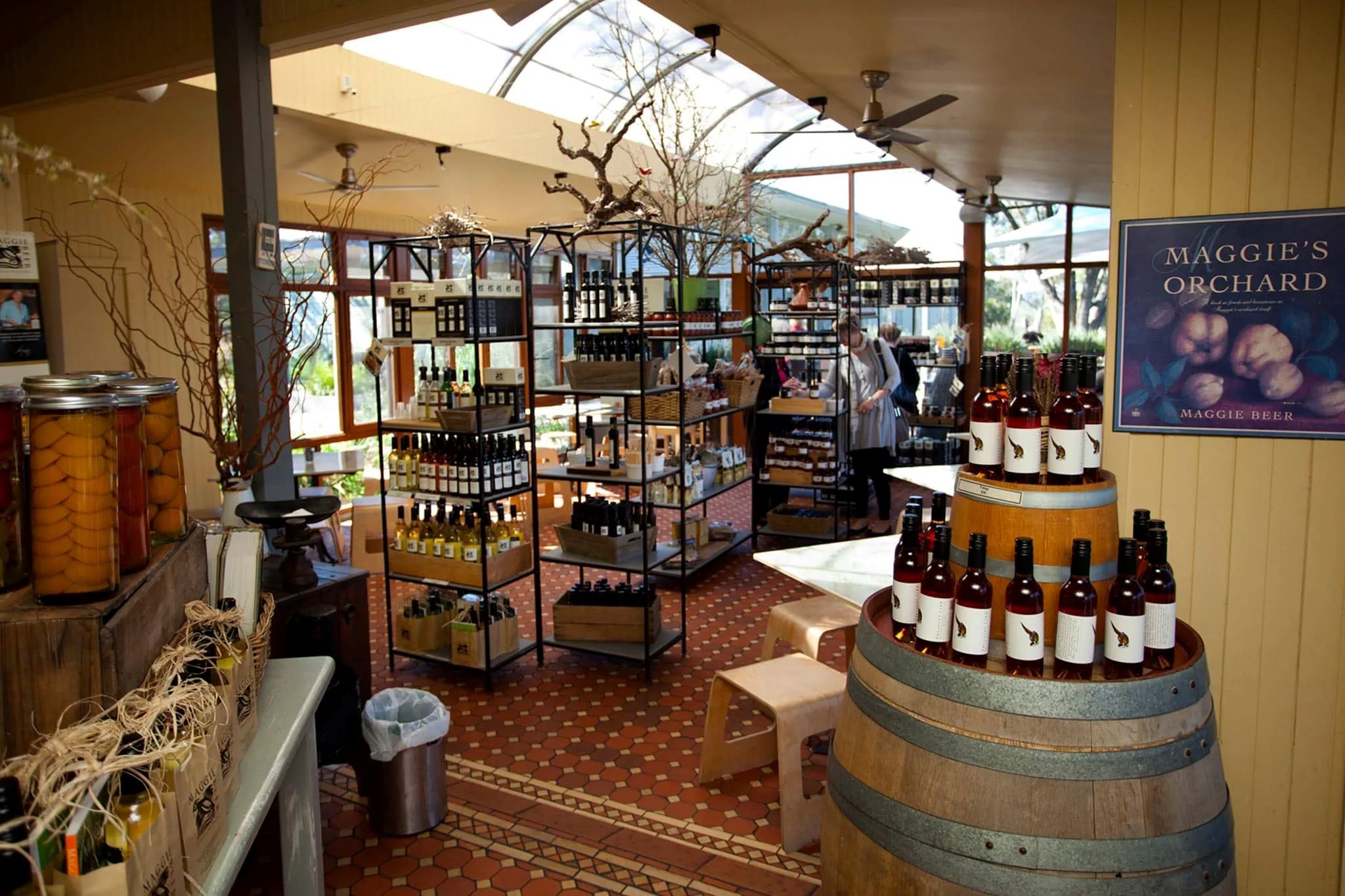 A rustic farm shop with shelves filled with jars of preserves and gourmet products. 