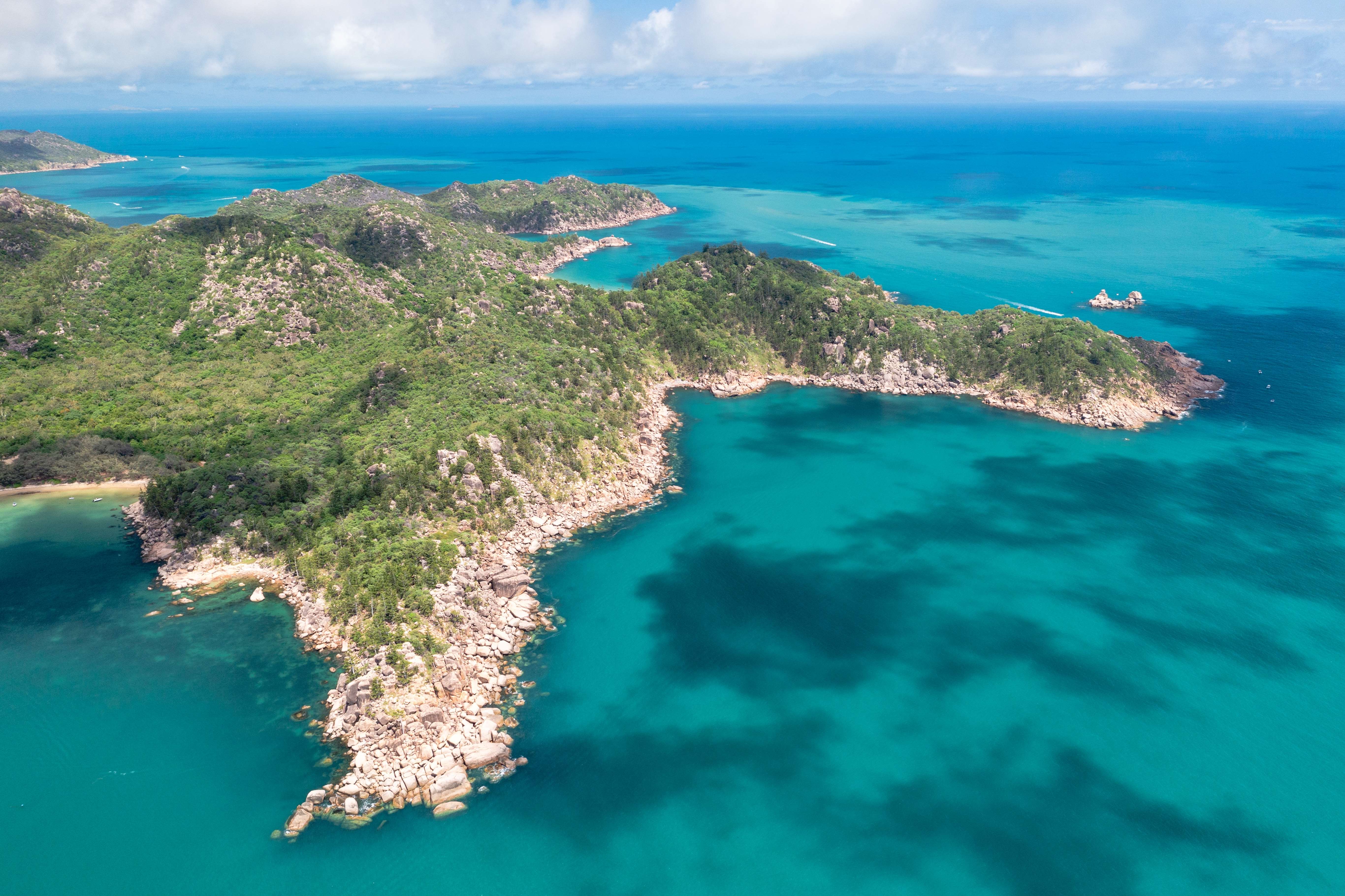 A scenic view of Magnetic Island, with golden beaches, turquoise waters, and the iconic Forts Walk trail.