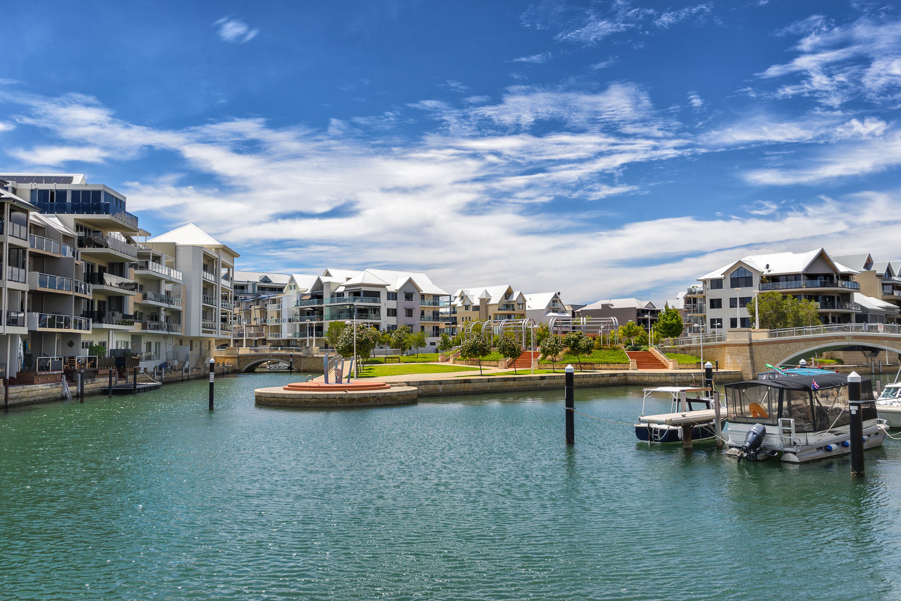 A tranquil scene from Mandurah's canals, showcasing boats gliding through calm waters. 