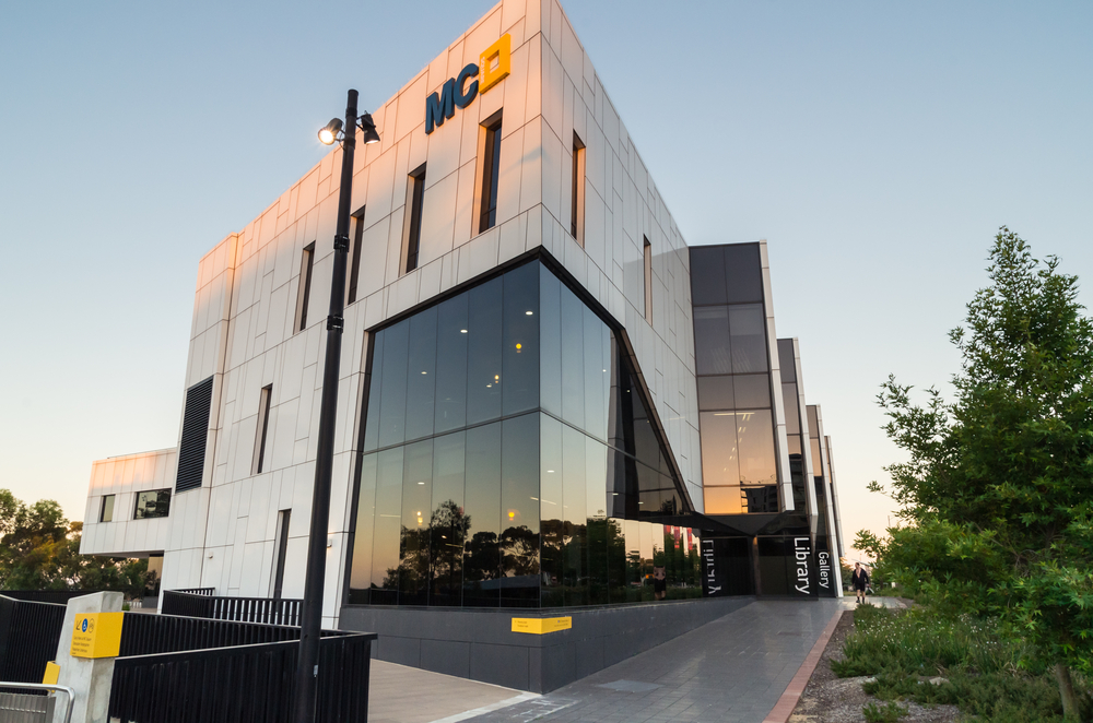 The outside view of Manningham Art Gallery presents a modern architectural design with clean lines and large windows that allow natural light to accentuate the art within. The building's facade is simple yet elegant, fitting seamlessly into the urban landscape of Manningham. Visitors can be seen approaching the gallery, which stands as a cultural landmark in the area, inviting the community to connect with diverse artistic expressions displayed throughout the year.
