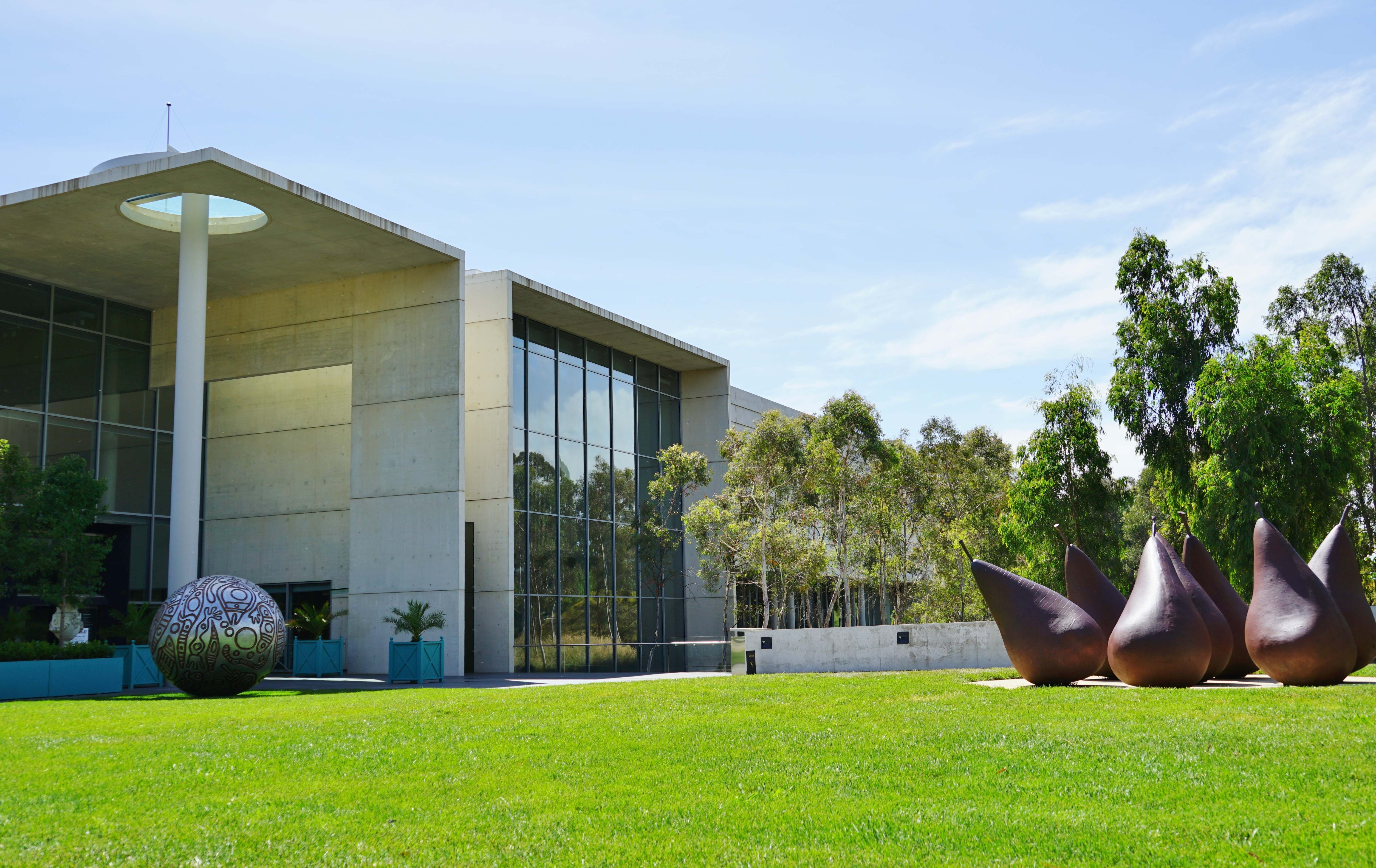 A captivating image of the National Gallery of Australia's modern architecture, with its distinctive design and glass facade shining in the sunlight. 