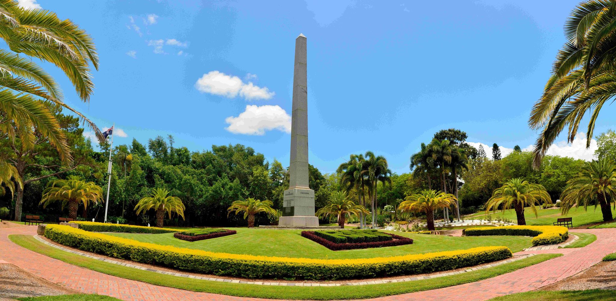 A tranquil image of the Rockhampton Botanic Gardens, featuring vibrant flowers, greenery, and winding pathways.