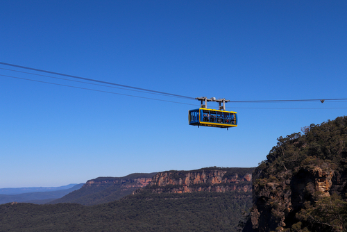 Inside the Jenolan Caves, showcasing awe-inspiring limestone formations, stalactites, and stalagmites, illuminated to reveal their intricate details, with the serene flow of an underground river adding to the cave's mystical ambiance