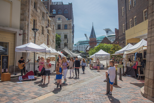 The charming and historic streets of The Rocks, where old-world cobblestone paths, heritage buildings, and bustling markets blend seamlessly, offering a rich historical experience right beside the modern skyline of Sydney's central business district.