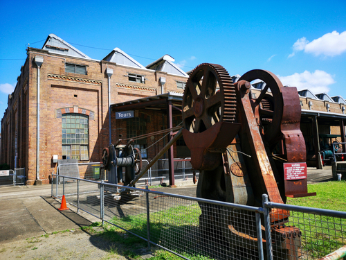 An engaging scene at The Workshops Rail Museum brings to life Ipswich's rich railway legacy, with visitors young and old exploring the vast collection of historic locomotives and railway artifacts. The image highlights hands-on exhibits and the grandeur of classic trains, portraying the museum as a dynamic space where history is both preserved and experienced.