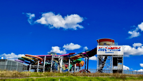 The modern facade of Blacktown Hospital, with its sleek architectural lines and expansive windows, standing under a clear blue sky. The hospital is a beacon of healthcare innovation and community support in Western Sydney, surrounded by landscaped gardens that add a touch of serenity to the bustling healthcare hub.