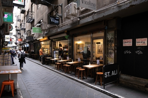 A lively Melbourne laneway, bursting with colourful street art, bustling cafes, and unique boutiques, capturing the city's vibrant and artistic urban culture.