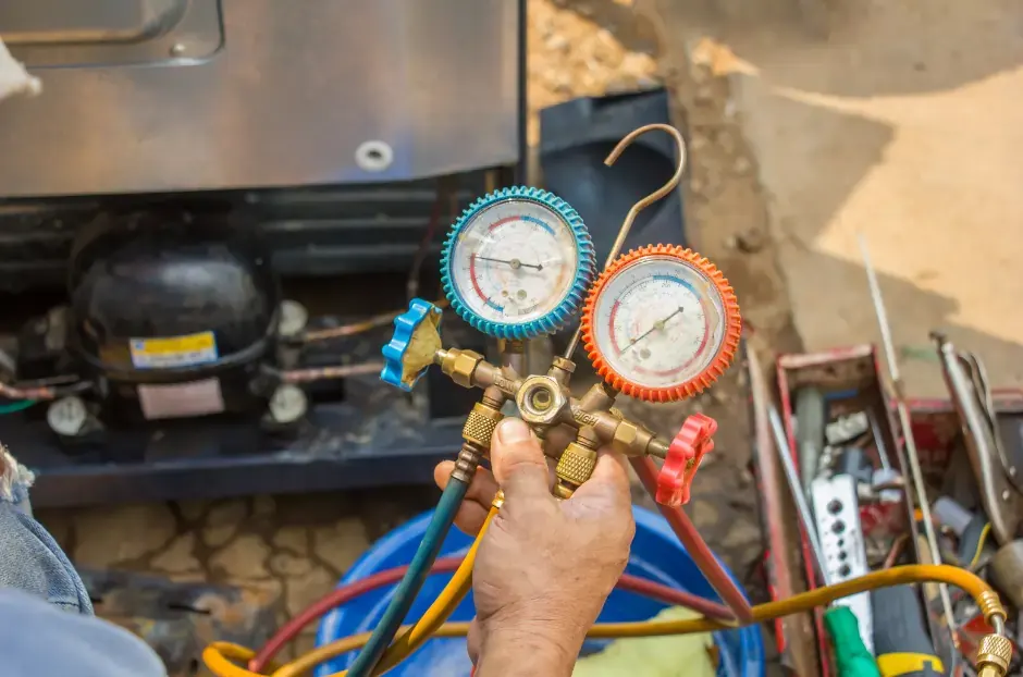 Sea Air Refrigeration Mechanic assessing the gas and pressure gauges during fridge maintenance and servicing checks