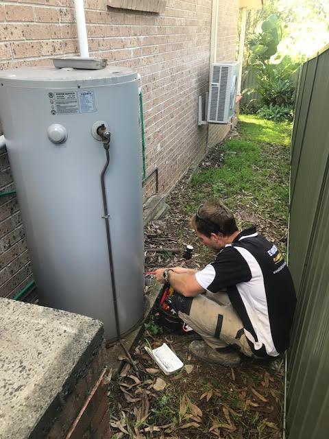 Plumber installing an electric hot water system