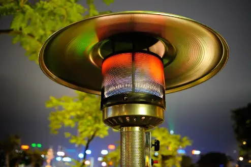 Outdoor gas heater on with the night sky behind it