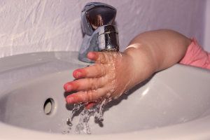 tap water running on childs hand