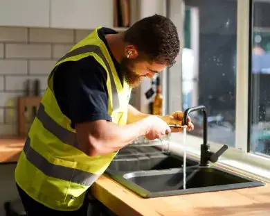 plumber fixing a kitchen tap