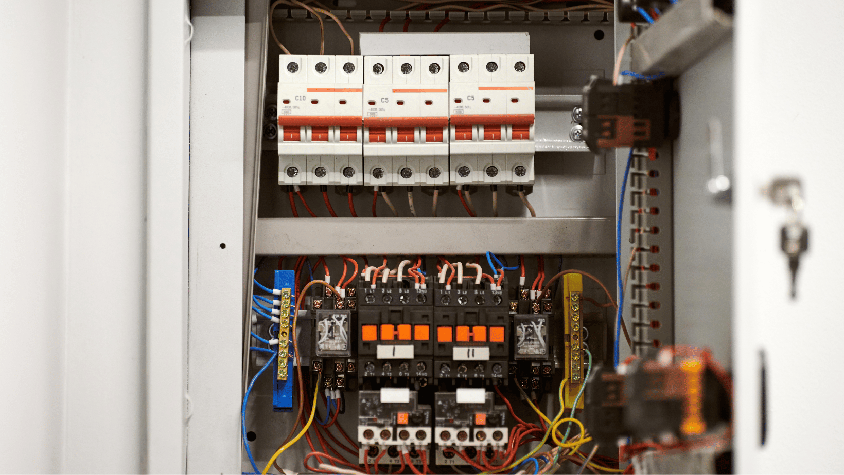 Row of electrical safety switches in electrical cupboard with switchboard