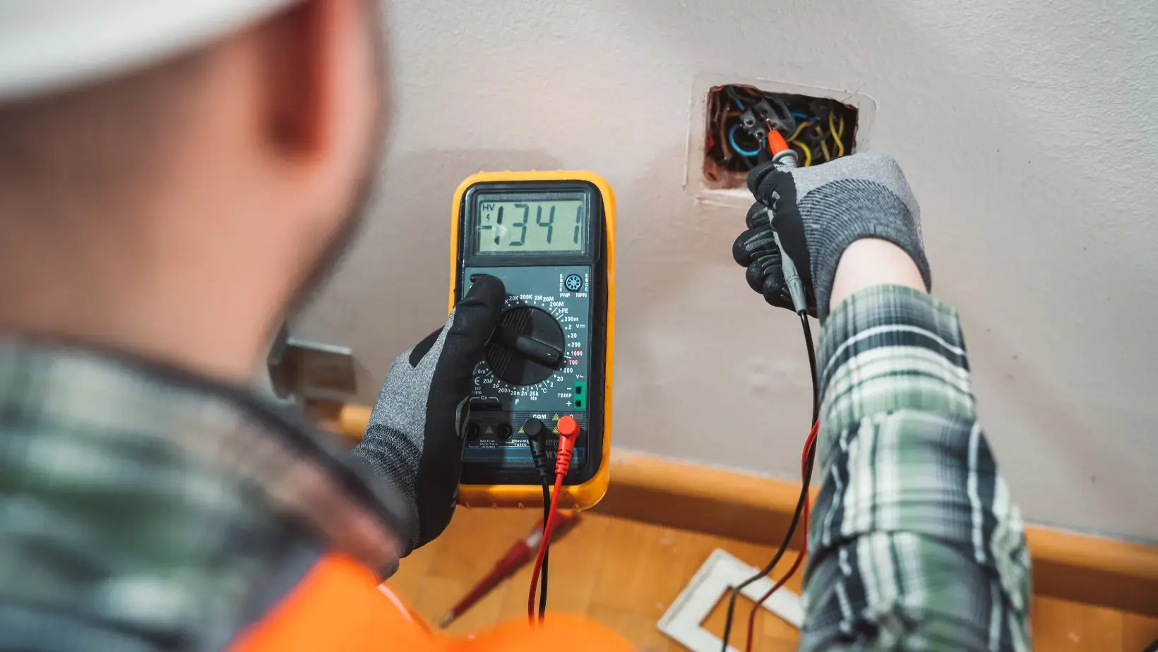 Electrician using specialised equipment to test electrical socket, plug and appliances