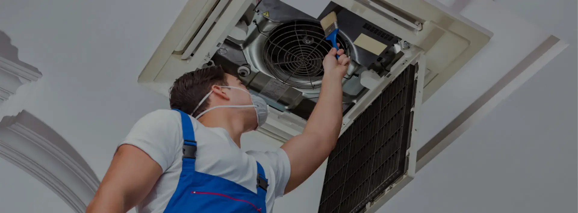 technician cleaning an AC unit