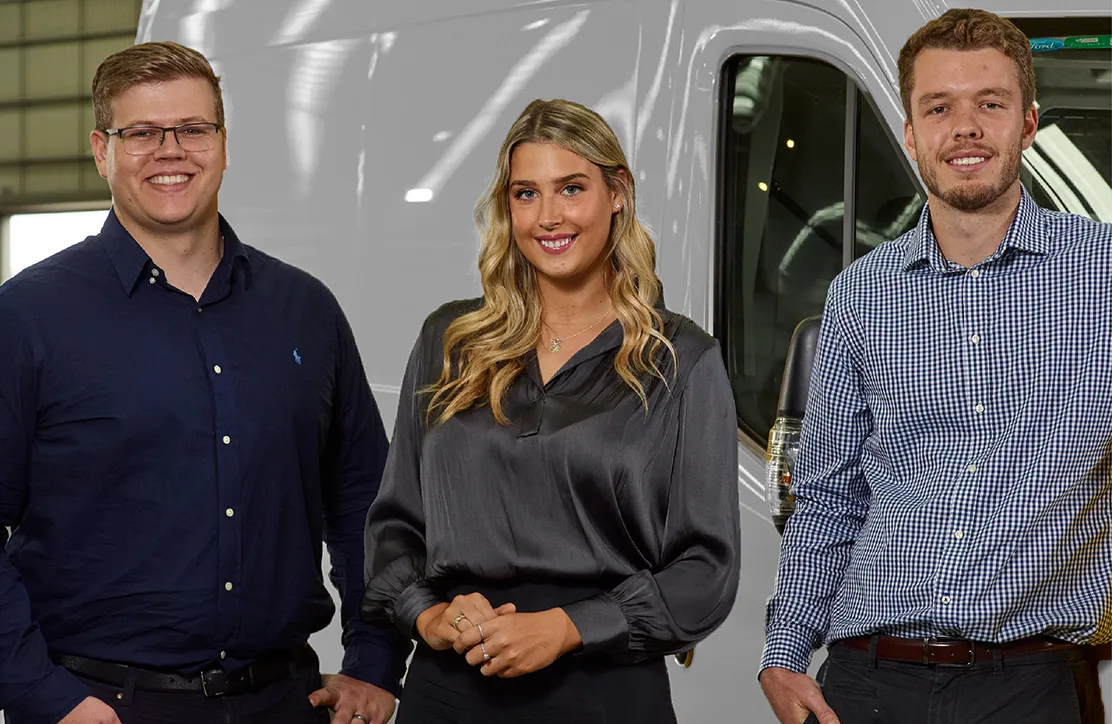 Employees standing beside a truck